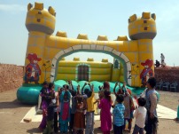 Children cheering for the bouncy castle in the brick kiln near Lahore, Pakistan
