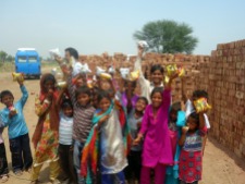Children cheering for their chips bags in the brick kiln near Lahore, Pakistan